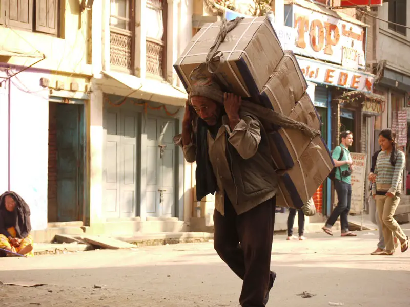 Man carrying a heavy load through the streets of Kathmandu
