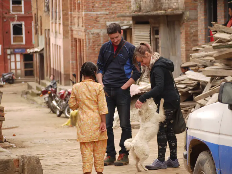 Noelle and Mike playing with someone's pet dog in Panauti, Nepal
