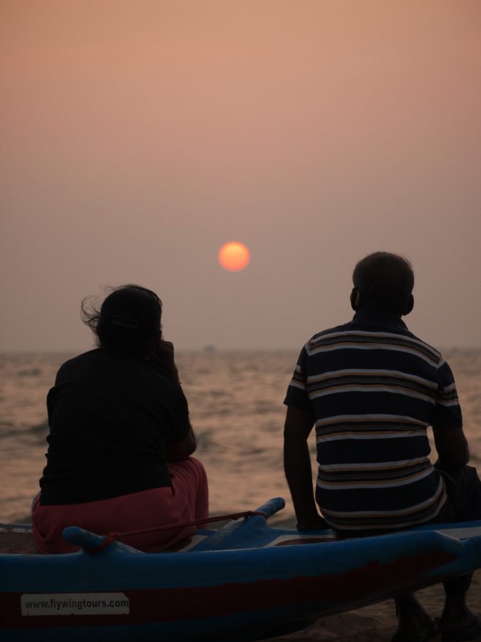 A local couple watch the sunset at Negombo Beach, Sri Lanka