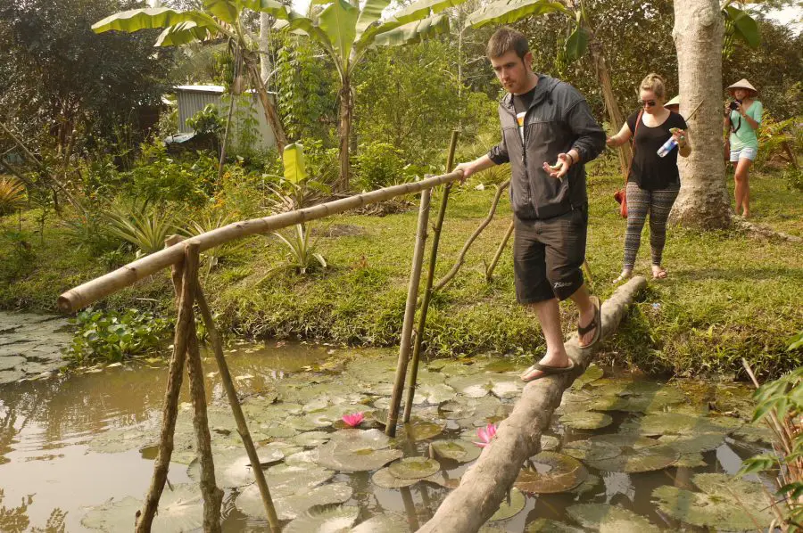 Michael and Noelle crossing a simple bridge inside the fruit garden