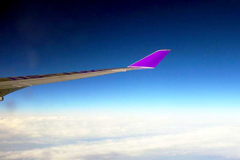 Air Travel in India - view of wing of an airplane in a blue sky