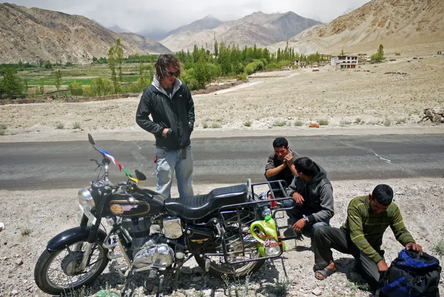 Locals helping to change a wheel on a rental motorbike near Leh in Northern India