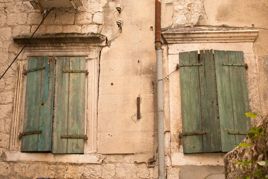 Green window shutters stand out against the stone buildings | Kotor's Old Town